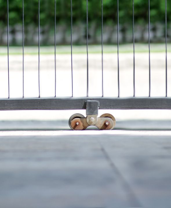 Nahaufnahme eines Schiebetors mit Laufrad auf einem Betonboden